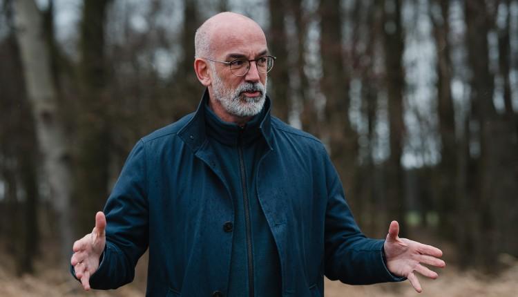 Mann steht mit ausgebreiteten Armen vor Wald | Prof. Dr. Christian Stegmann